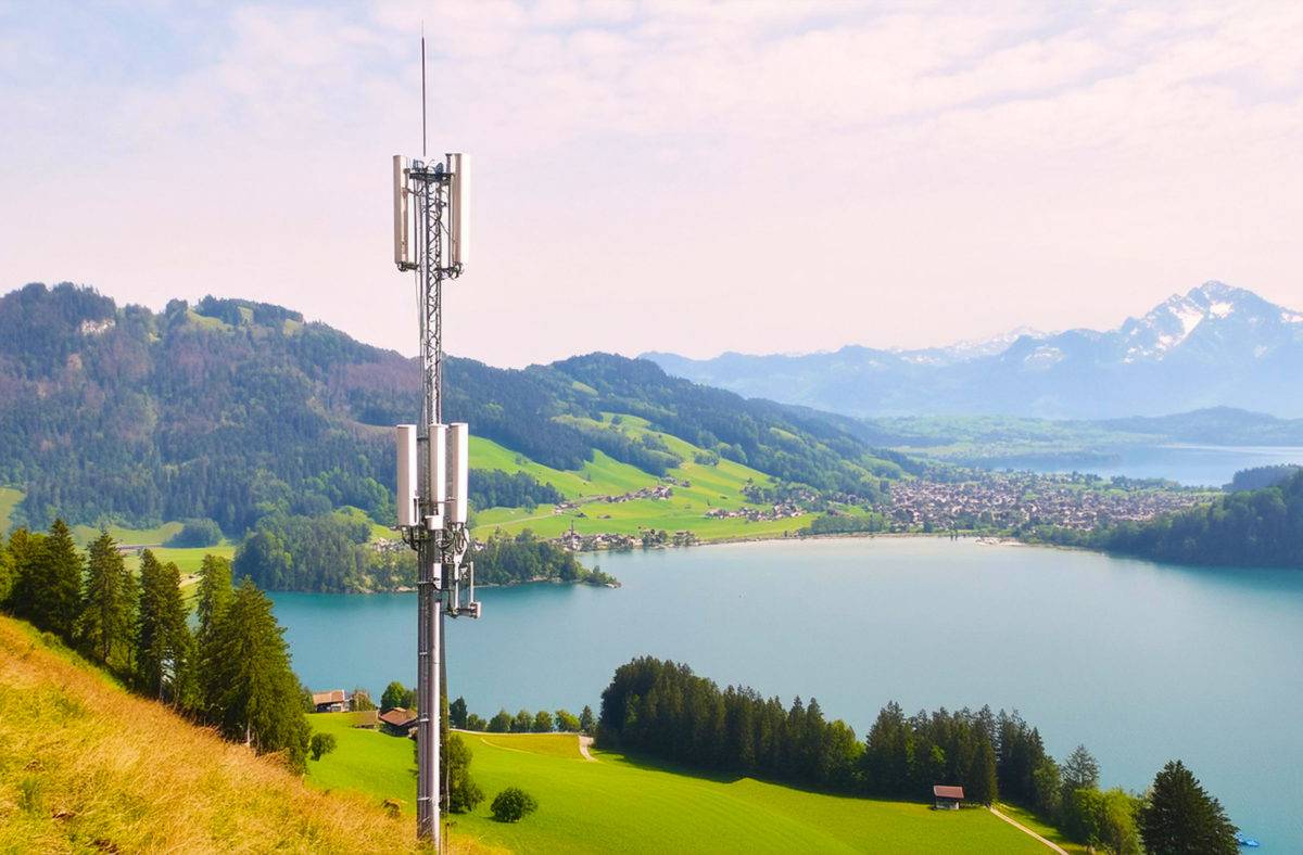Prompt Photoshop: une antenne 5G en pleine nature avec au loin un lac, des montagnes et un petit village en Suisse. Prompt Photoshop: une antenne 5G en pleine nature avec au loin un lac, des montagnes et un petit village en Suisse.